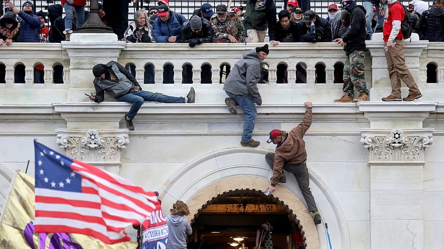A mob of supporters of US President Donald Trump fight with members of law enforcement at a door they broke open as they storm the USCapitol Building in Washington, January 6, 2021. Credit: Reuters File Photo