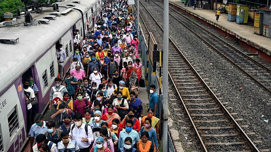 Commuters walk along a platform after arriving in a special service local train in West Bengal. Credit: AFP Photo