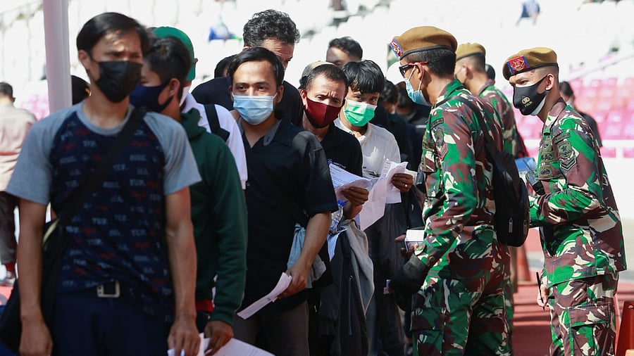 People wearing protective face masks stand in line while waiting to receive their dose of the vaccine against the coronavirus disease, during the mass vaccination program at Gelora Bung Karno Stadium, in Jakarta. Credit: Reuters photo