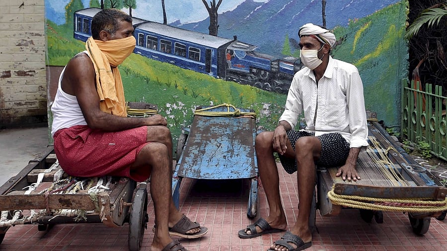 Railway porters rest at Sealdah Station during the ongoing Covid-induced lockdown in Kolkata, Friday, July 2, 2021. Credit: PTI Photo