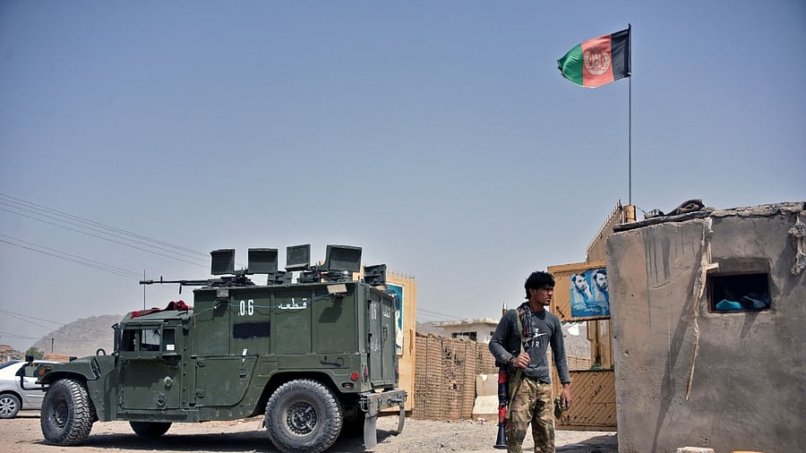 An Afghan security personnel stands guard at the site of a car bomb attack in Kandahar. Credit: AFP Photo
