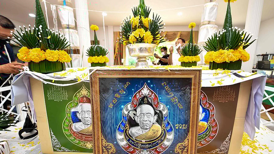 Replicas of the digital amulets bearing an image of the face of Buddhist abbot Luang Pu Heng. Credit: AFP Photo