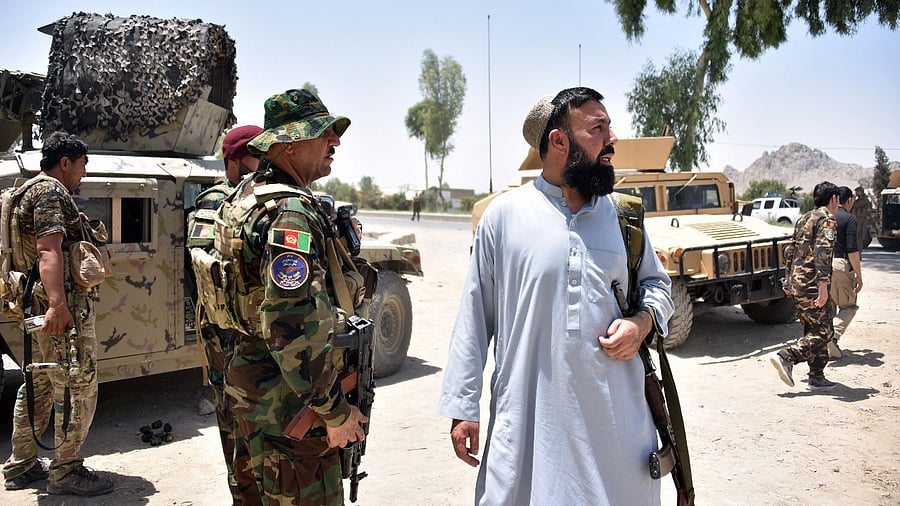 Afghan security personnel stand guard along the road amid ongoing fight between Afghan security forces and Taliban fighters in Kandahar. Credit: AFP Photo