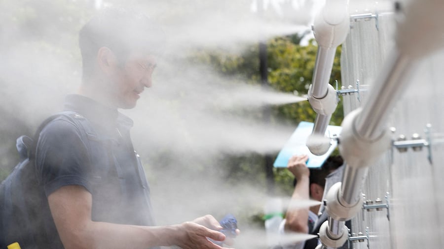 A man cools off at a mist station installed at Shiokaze Park. Credit: AFP file photo