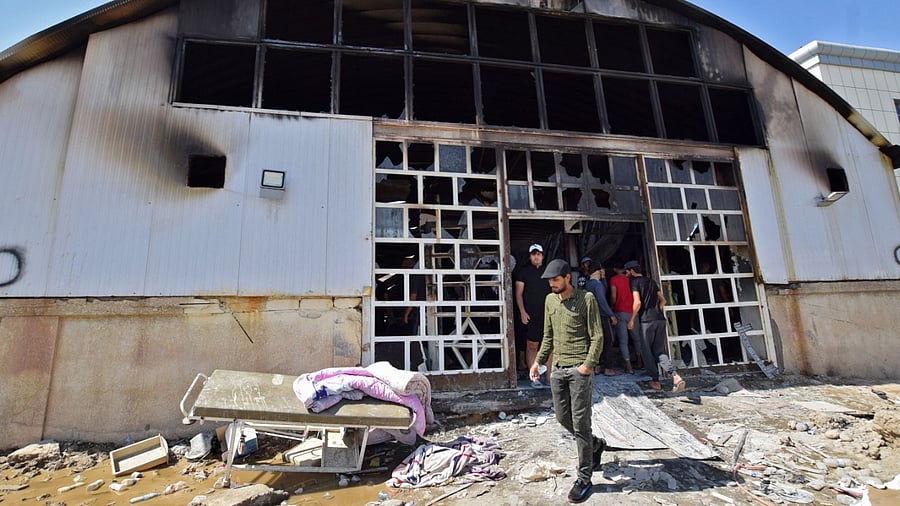 People gather at the ravaged coronavirus isolation ward of Al-Hussein hospital after a massive fire overnight, in the southern Iraqi city of Nasiriyah, on July 13, 2021. Credit: AFP Photo