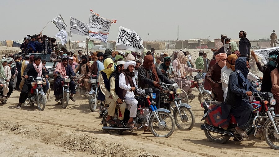People holding Taliban flags, gather near the Friendship Gate crossing point in the Pakistan-Afghanistan border town of Chaman. Credit: Reuters Photo