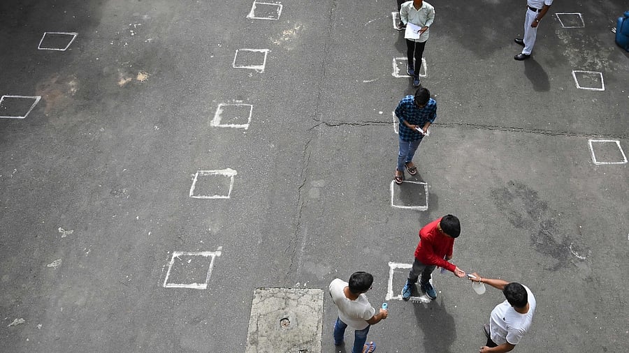 Students maintain social distancing amid the Covid-19 coronavirus pandemic as they queue enter an examination hall to sit for the state Joint Entrance Examination (JEE) test in Kolkata. Credit: AFP Photo