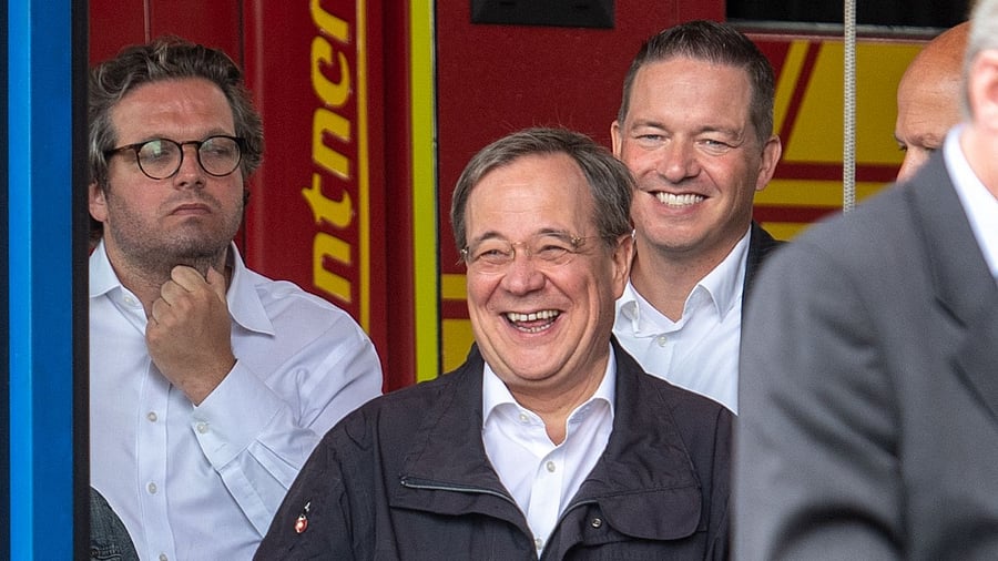 North Rhine-Westphalia's State Premier, Christian Democratic Union (CDU) leader and CDU's candidate for Chancellery Armin Laschet (C) laoughs out while the German President (unseen) delivers a speech after they visited the Rhein-Erft fire and rescue control center and in Erftstadt, western Germany. Credit: AFP Photo