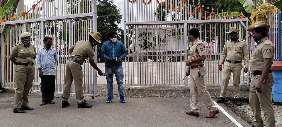 KSISF personnel screen a visitor at the gate of the garden in front of Harangi reservoir.