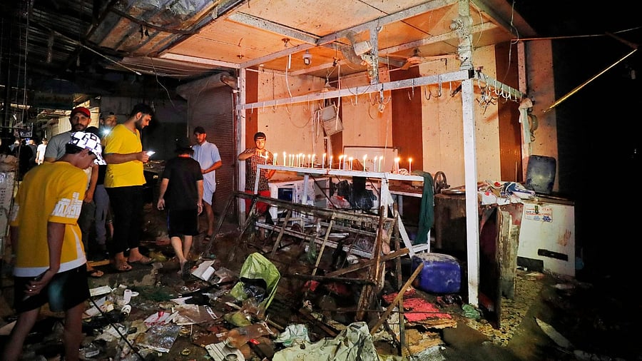 Iraqis light candles at the site of the explosion in a popular market in Sadr City, east of Baghdad. Credit: AFP Photo