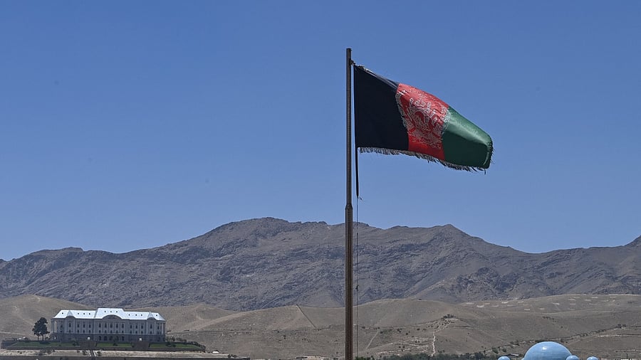 The Afghanistan flag and a palatial building on the backdrop of the hills. Credit: AFP File Photo