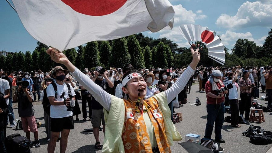 Kyoko Ishikawa (C), who has attended every Summer Olympics in the past 30 years, express her gratitude as Blue Impulse, Japan's Air Self Defense Force (JASDF) aerobatic team. Credit: AFP Photo