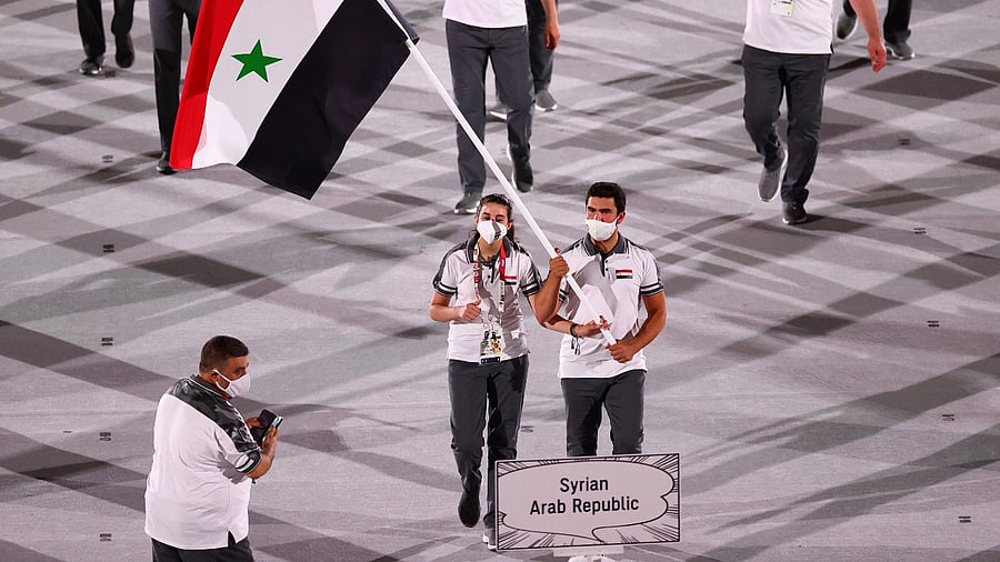 Flag bearers Hend Zaza of Syria and Ahmad Saber Hamcho of Syria lead their contingent during the athletes parade at the opening ceremony. Credit: Reuters photo