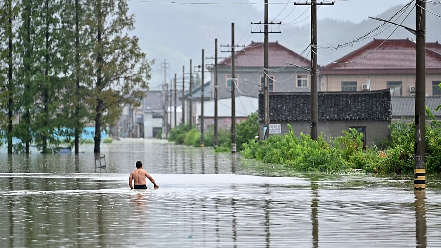 A man walks down a flooded area in Yuyao near the city of Ningbo in eastern China's Zhejiang province. Credit: AFP Photo