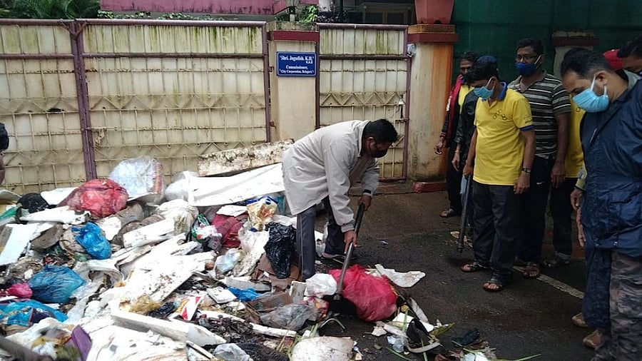 MLA Abhay Patil dumps garbage in front of residence of BCC Commissioner, in Belagavi on Sunday. Credit: DH photo