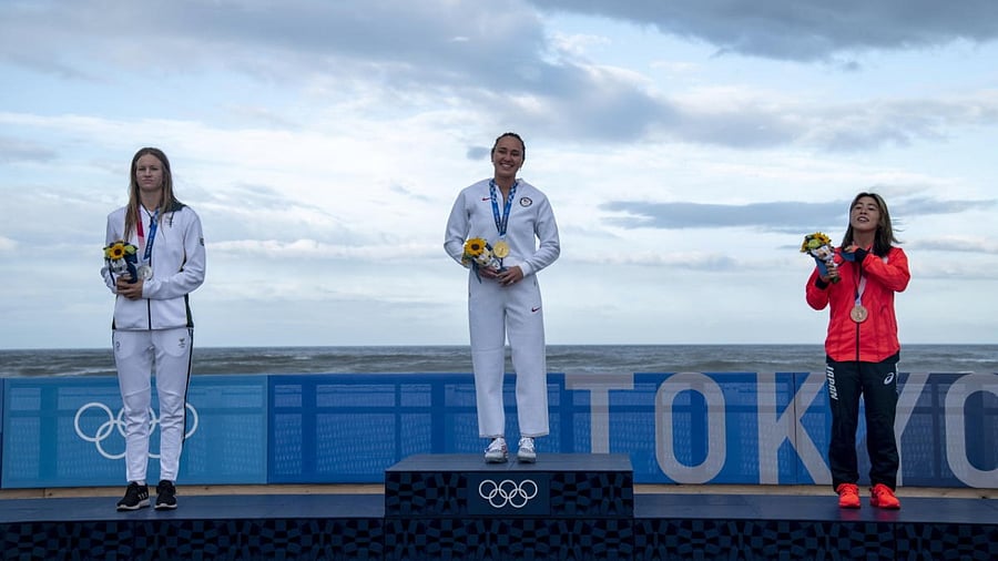 Gold medallist Carissa Moore of the United States celebrates on the podium with silver medallist Bianca Buitendag of South Africa and bronze medallist Amuro Tsuzuki of Japan. Credit: Reuters Photo