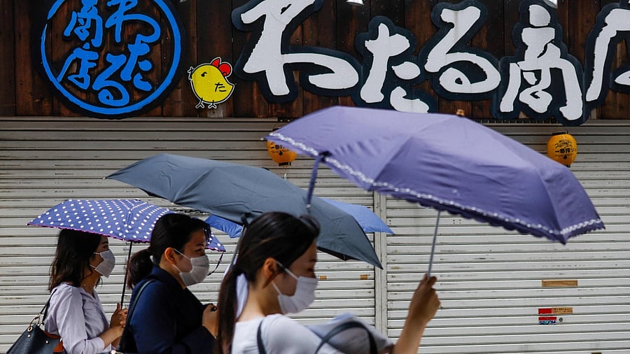 People shelter from the rain as Tropical Storm Nepartak approaches. Credit: AFP Photo