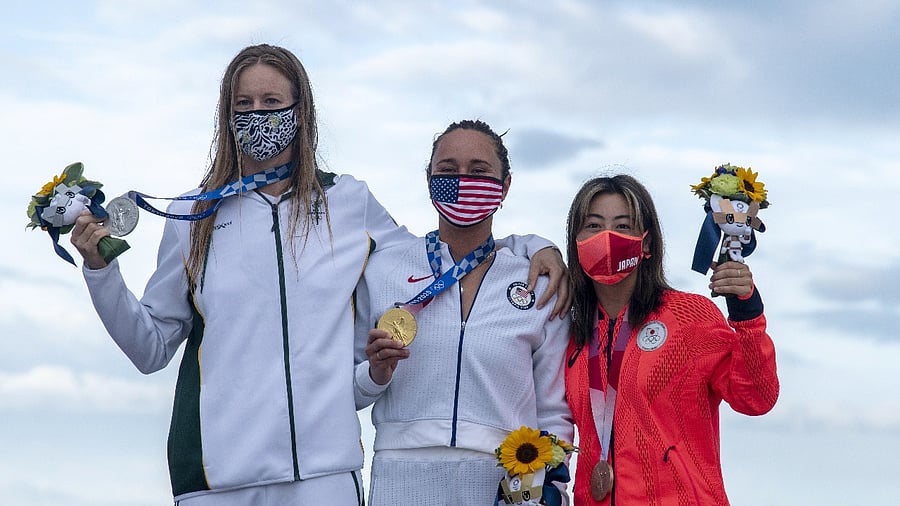 Gold medallist Carissa Moore of the United States celebrates on the podium with silver medallist Bianca Buitendag of South Africa and bronze medallist Amuro Tsuzuki of Japan. Credit: Reuters photo