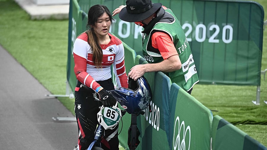 Japan's Sae Hatakeyama is comforted by her coach after falling in the cycling BMX racing women's quarter-finals run. Credit: AFP Photo