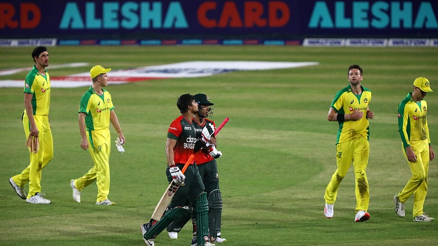  Bangladesh's Afif Hossain and Nurul Hasan walk past Australia's players after winning their match. Credit: Reuters Photo