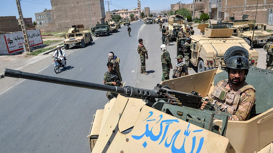 An Afghan National Army commando stands guard on top of a vehicle along the road in Enjil district of Herat province on August 1, 2021, as skirmishes between Afghan National Army and Taliban continues. Credit: AFP Photo