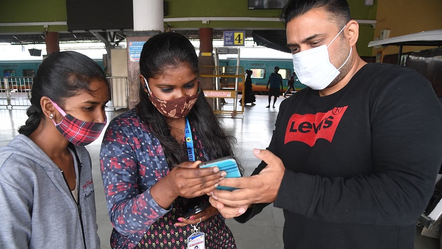 A BBMP official checks a negative report of a traveller at Yeshwantpur railway station on Wednesday. Credit: DH Photo