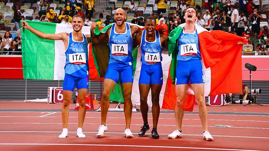 (L to R) Italians Lorenzo Patta, Lamont Marcell Jacobs, Eseosa Desalu and Filippo Tortu celebrate their 4x100m relay win. Credit: AFP Photo