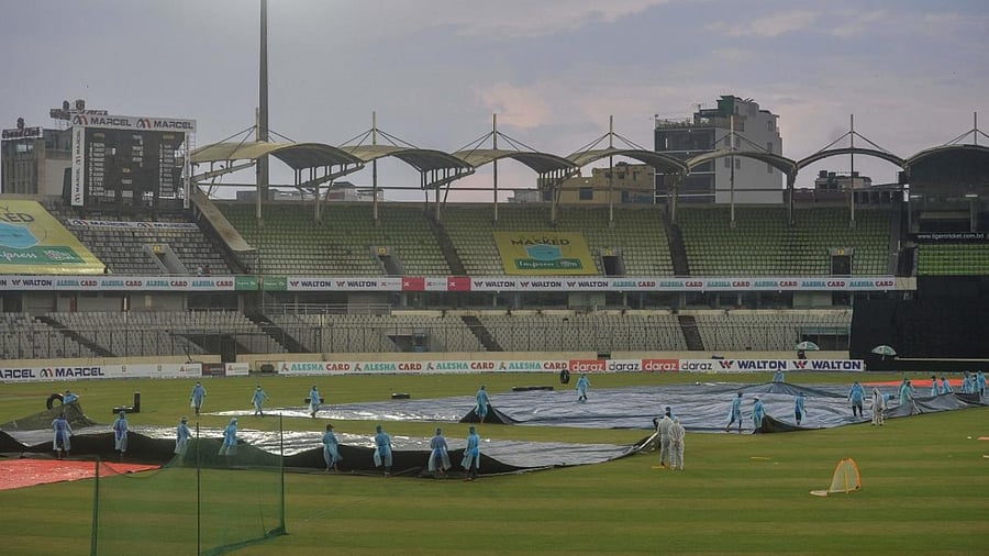 Ground staff prepare to pull away the cover from the pitch before the third Twenty20 international cricket match between Bangladesh and Australia at the Sher-e-Bangla National Cricket Stadium in Dhaka. Credit: AFP Photo