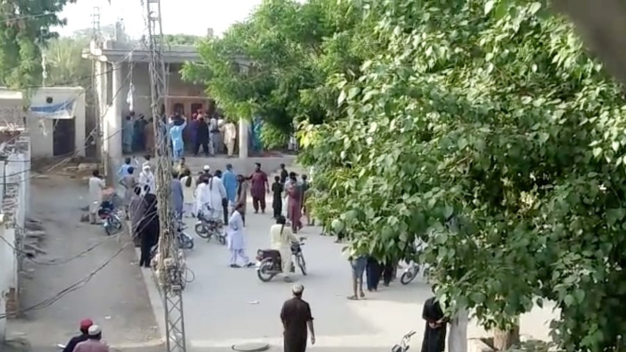People gather outside a Hindu temple that was set on fire by an angry mob after reports that a Hindu boy had urinated in the library of an Islamic seminary, in Bhong. Credit: Reuters photo