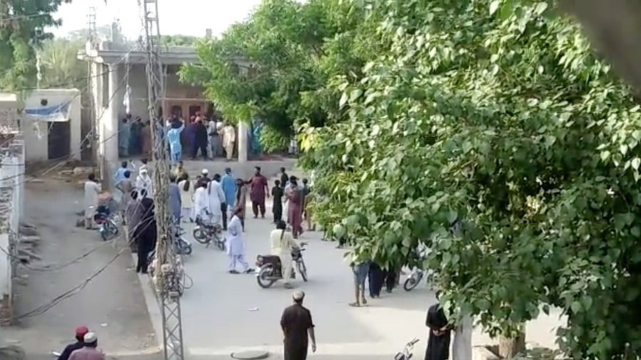 people gather outside the Hindu temple that was set on fire by an angry mob in Pakistan. Credit: Reuters Photo