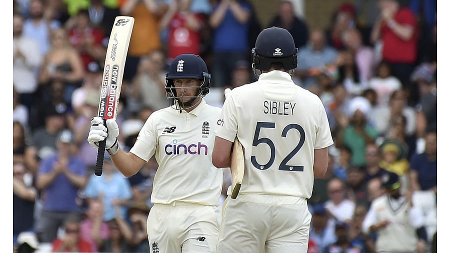 England captain Joe Root, left, raises his bat to celebrate scoring fifty runs during the fourth day of first test cricket match between England and India, at Trent Bridge in Nottingham. Credit: AP/PTI Photo