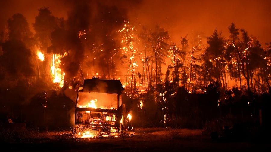 A wildfire burns in the village of Vasilika, on Evia island, Greece. Credit: Reuters Photo