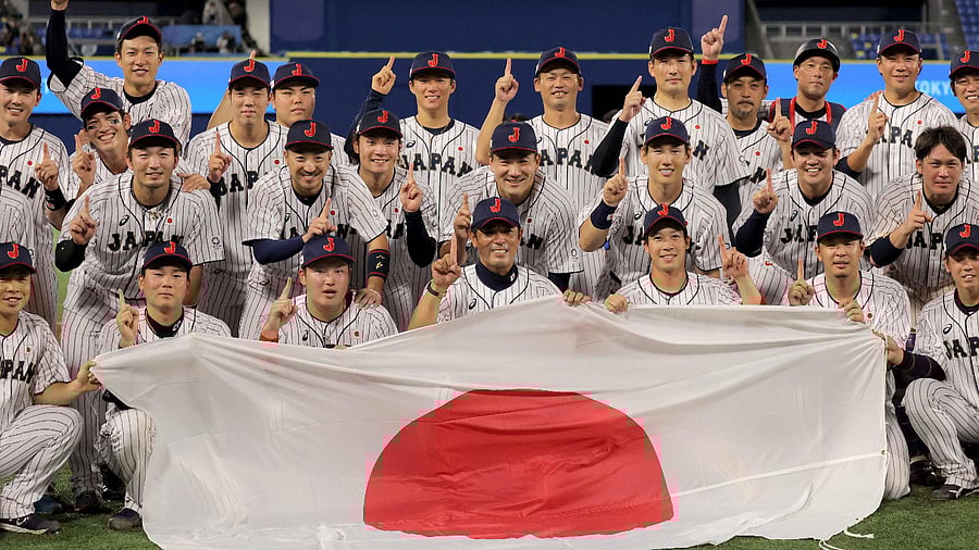 Japan's baseball players and coaches pose for a family photo after their victory during the Tokyo 2020 Olympic Games baseball gold medal game between USA and Japan at Yokohama Baseball Stadium in Yokohama, Japan. Credit: AFP Photo