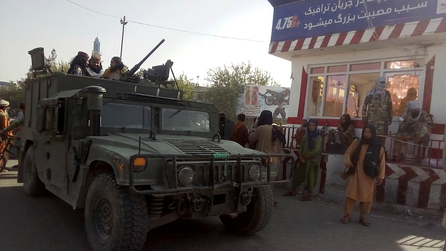Taliban fighters stand guard at a checkpoint. Credit: AP Photo