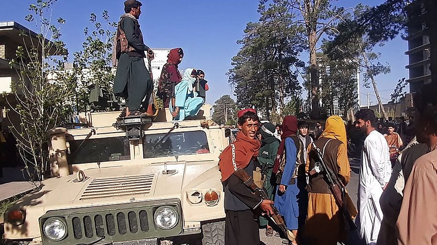 Taliban fighters stand guard along the roadside in Herat, Afghanistan's third biggest city, after government forces pulled out the day before following weeks of being under siege. Credit: AFP File Photo