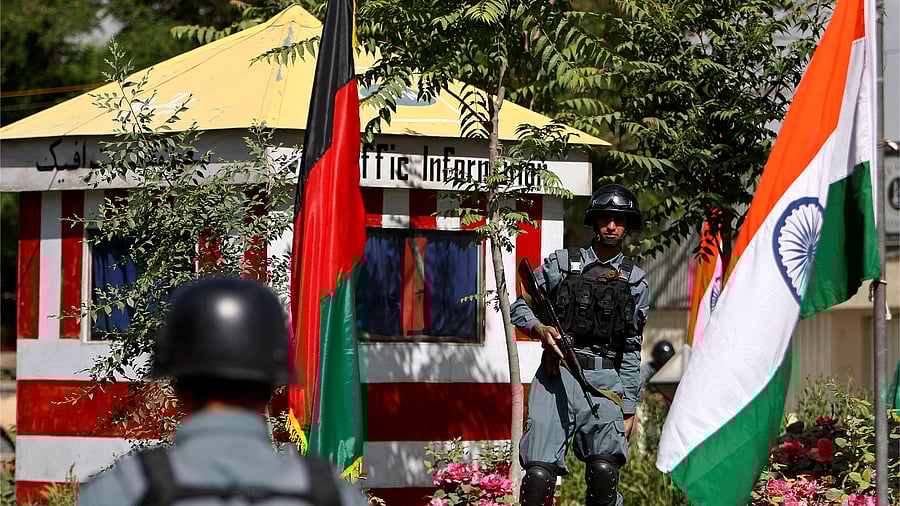 Afghan policemen stand guard next to Indian and Afghan national flags, at a check point in Kabul city. Credit: Reuters Photo
