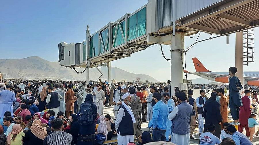 Afghans crowd at the tarmac of the Kabul airport. Credit: AFP Photo