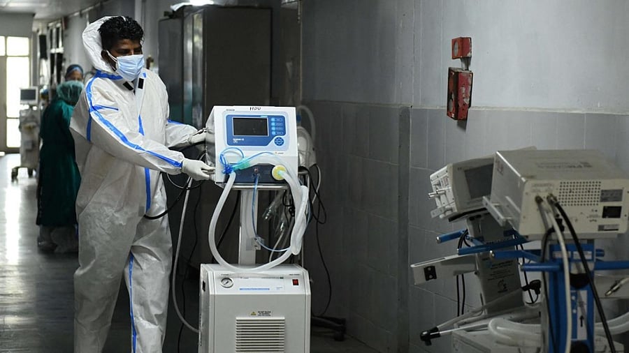 A health worker wearing protective gear pushes a defunct ventilator machine in the corridor of a hospital amid Covid-19 coronavirus pandemic in Amritsar. Credit: AFP Photo