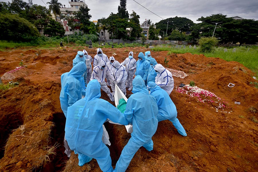 Helping Hand volunteers conduct burials in a respectful manner while conforming to safety norms. DH Photo by Pushkar V