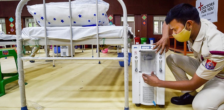 A volunteer prepares beds with oxygen concentrators. Credit: PTI Photo