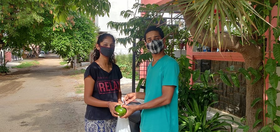 Avocados from Kodagu are in demand this season. Adarsh Mandanna MB (right) seen delivering the fruit to a resident.