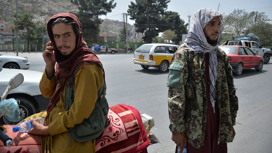 Taliban fighters stand along a road in Kabul. Credit: AFP Photo