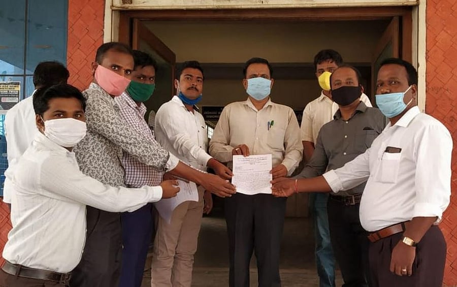 Guest teachers and AIDYO members submit memorandum to tahsildar’s office staff in Hubballi on June 25, 2020. Credit: DH Photo.