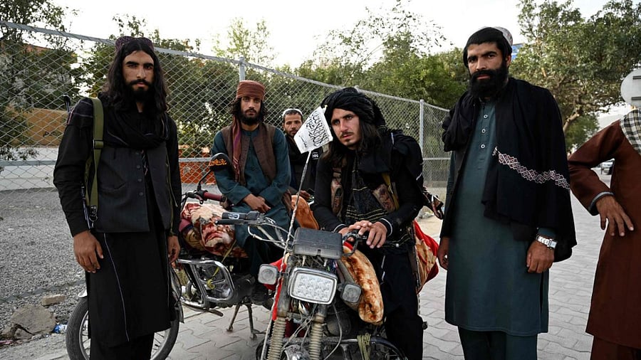 Taliban fighters stand along a road in Kabul. Credit: AFP Photo