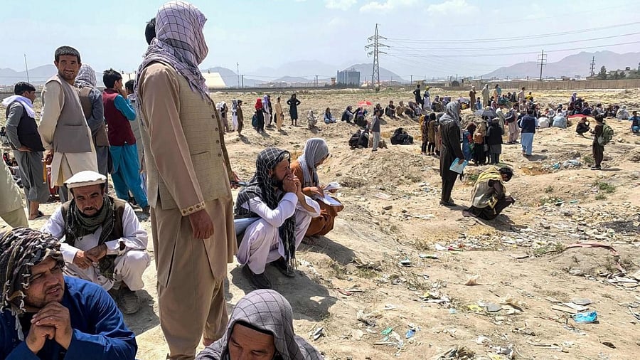 Afghan people gather as they wait to board a US military aircraft to leave the country, at a military airport in Kabul on August 20, 2021 days after Taliban's military takeover of Afghanistan. Credit: AFP Photo