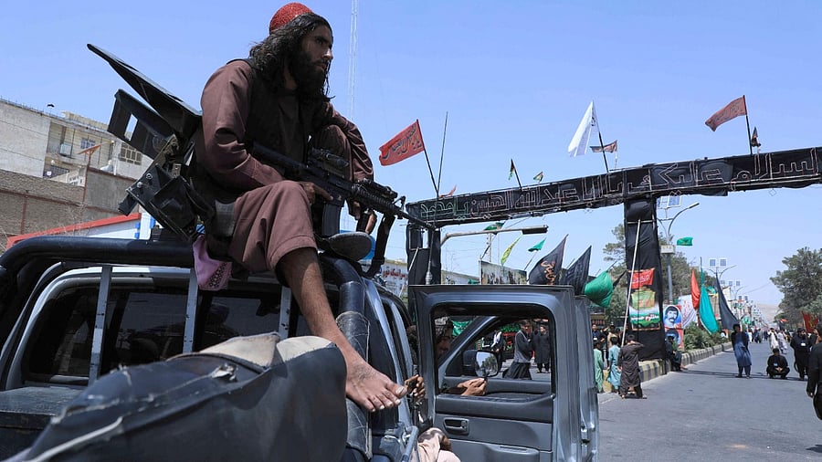 Taliban fighter stands guard atop a vehicle. Credit: AFP File Photo