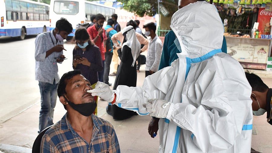 Swab tests for passengers arriving at a BMTC bus stand in Bengaluru. Credit: DH Photo