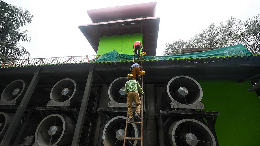 Workers climb a ladder at the 25-metre (82-foot) high smog tower, built to purify the air during pollution season. Credit: AFP Photo