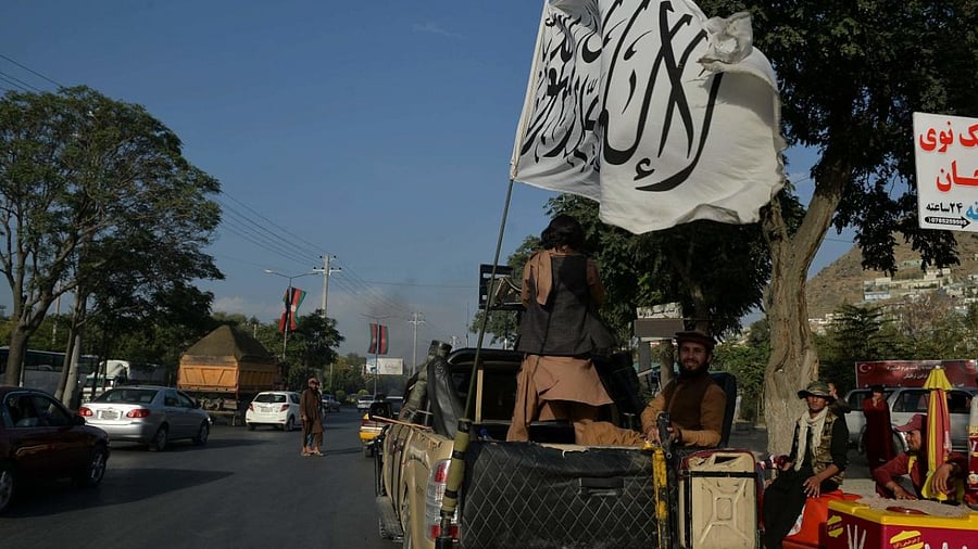 Taliban fighters travel on a vehicle mounted with the Taliban flag in the Karte Mamorin area of Kabul city, Kabul. Credit: AFP Photo