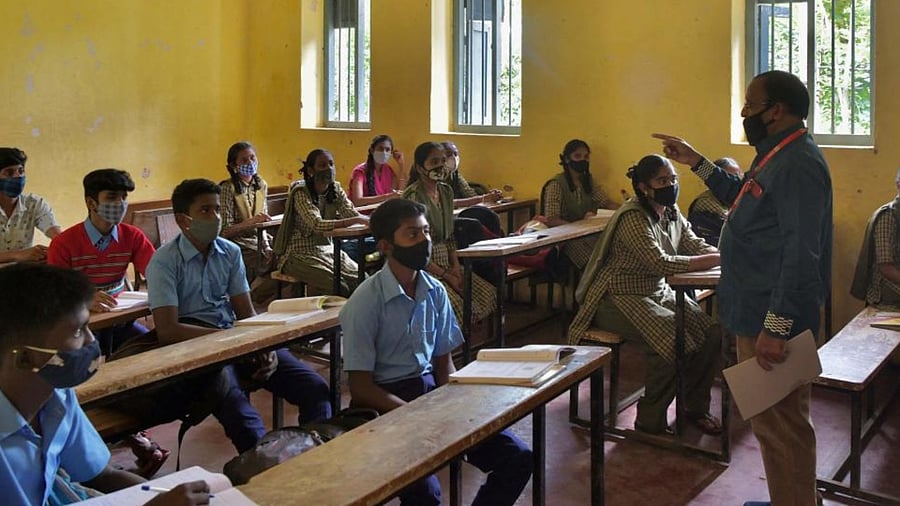 Students of a government school attend their class on the first day of reopening of schools for the higher secondary classes with 50 percent capacity in Bengaluru on August 23, 2021. Credit: AFP Photo